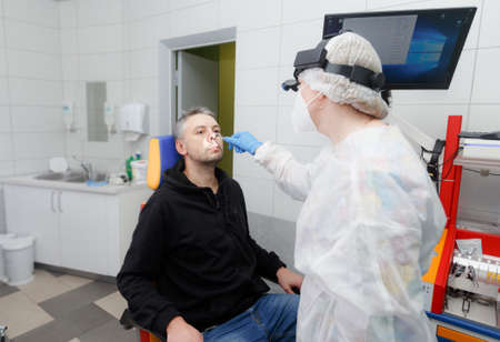 Profile photo of an otolaryngologist examining a patients nose.の写真素材