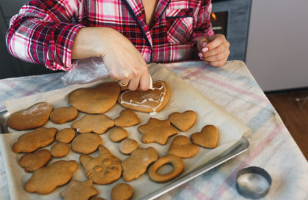 the girl is decorated with white frosting Christmas ginger cookies. Preparing for the New Year