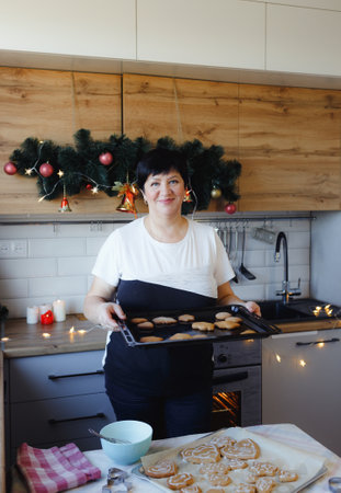 woman at home in the kitchen cooking Christmas treatsの写真素材
