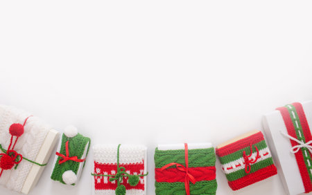 Christmas boxes are decorated with knitted ribbons. Isolated white background top view. Red, green ornament.の写真素材