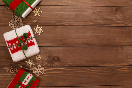 Christmas boxes are decorated with knitted ribbons. wooden background top view. Red, green ornament.の写真素材