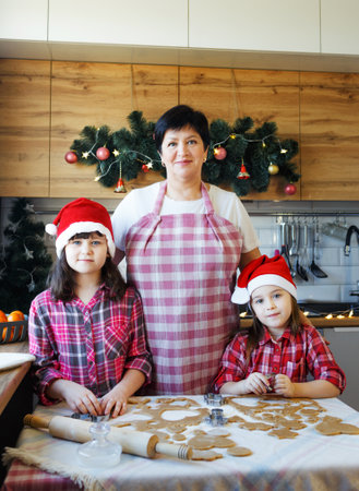 grandma and two granddaughters cook cookies in the kitchen.の写真素材