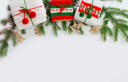 Christmas box decorated with knitted tapes the branches of the tree. Isolated white background top view. Red, green ornament.の写真素材