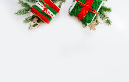 Christmas box decorated with knitted tapes the branches of the tree. Isolated white background top view. Red, green ornament.の写真素材
