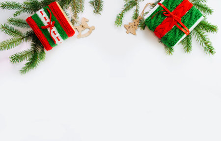 Christmas box decorated with knitted tapes the branches of the tree. Isolated white background top view. Red, green ornament.の写真素材