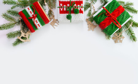 Christmas box decorated with knitted tapes the branches of the tree. Isolated white background top view. Red, green ornament.の写真素材