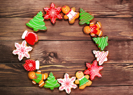 colorful ginger cookies in a bright glaze are laid out on a wooden background.Ginger men. Christmas cookies. The view from the top.の写真素材