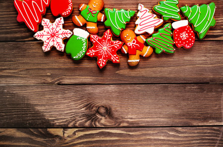 colorful ginger cookies in a bright glaze are laid out on a wooden background.Ginger men. Christmas cookies. The view from the top.の写真素材