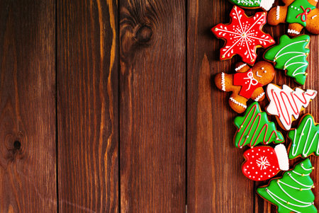 colorful ginger cookies in a bright glaze are laid out on a wooden background.Ginger men. Christmas cookies. The view from the top.の写真素材