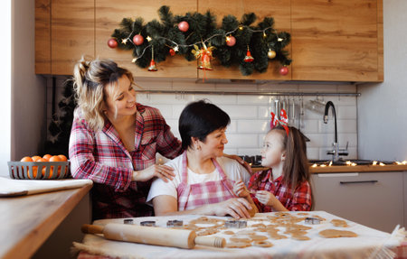 A friendly family prepares ginger cookies in the kitchen.の写真素材