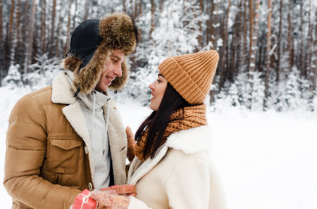 A young happy couple embrace in a snow-covered forest. Happy weekend. Valentines Dayの写真素材