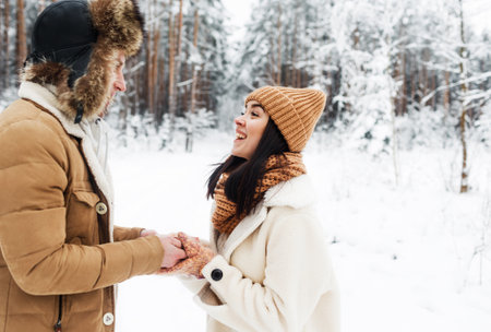 A young happy couple embrace in a snow-covered forest. Happy weekend. Valentines Dayの写真素材