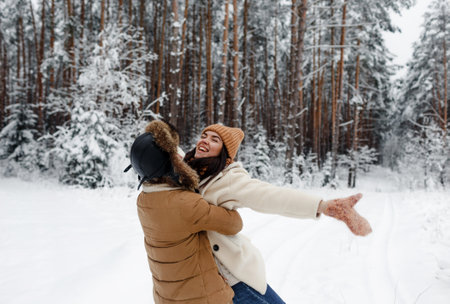A young happy couple embrace in a snow-covered forest. Happy weekend. Valentines Dayの写真素材