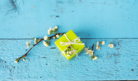 a box of light green color on a wooden blue background, spring flowers. Top view.の写真素材