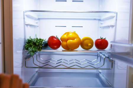 bright vegetables and fruits are on the shelf in the refrigerator.の写真素材