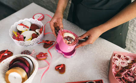 the girl packs the cakes in colorful gift boxes. Preparing for the celebrationの写真素材