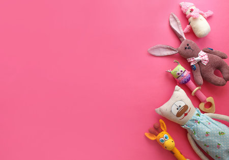lots of colorful children's toys laid out on a pink background top view. space for textの写真素材