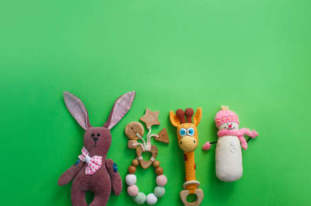 Beautiful children's toys are laid out on a green background top view. space for textの写真素材