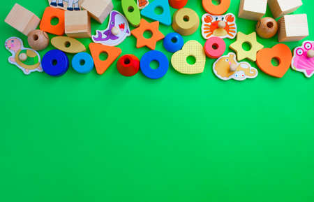Beautiful children's toys are laid out on a green background top view. space for textの写真素材