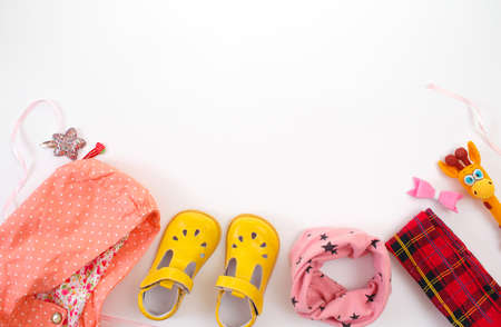 children's clothing and shoes are laid out on a white background top view. Space for the text.の写真素材
