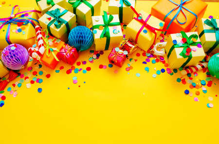 colorful gift boxes and confetti on a yellow background top view. Space for the text.の写真素材