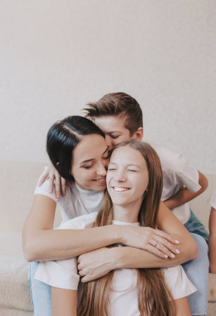 young beautiful mother hugs her daughter all together smiling happily. the concept of the joy of family happinessの写真素材