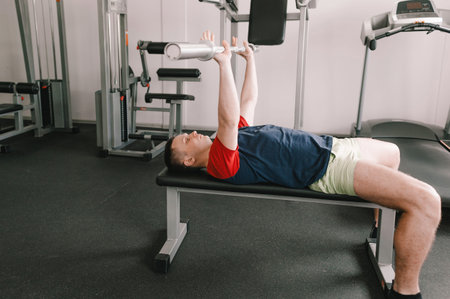 a man lifts a barbell in the gym while lying on a bench. healthy lifestyle