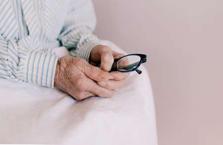 the old man's hands hold the glasses close-up. deep old ageの写真素材