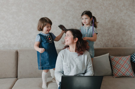 two little girls play with their mother, do her hair, comb her hair. Caring mother