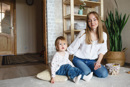 a happy and caring young mother plays with her little daughter. happily spend time with your childの写真素材