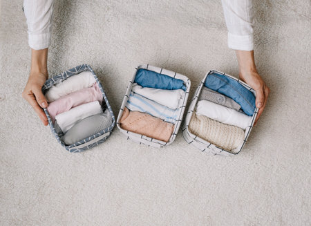 a neat housewife puts things in a laundry container during general cleaning with the help of a...