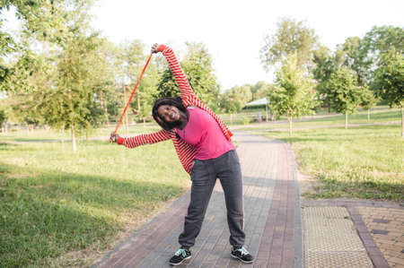 the concept of fitness, sports, training, park and lifestyle smiling African American woman training with a rope outdoorsの写真素材