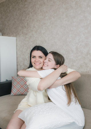 a girl hugs an excited young mother, shows love and affection, sharing a close tender moment...
