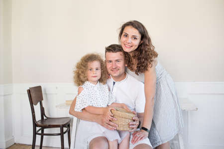 mom, dad and daughter smile at the camera. happy familyの写真素材