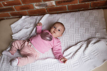 newborn baby in pink clothes in a crib, the concept of childrenの写真素材