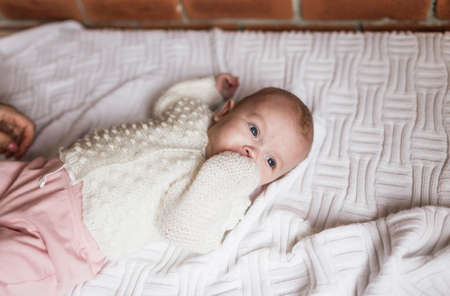 a newborn baby in a crib, the concept of children and the birthの写真素材