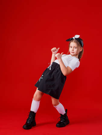 Portrait of a cute little girl on a red backgroundの写真素材