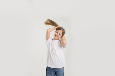 portrait of a young girl holding her hair with cookies on a white background.の写真素材