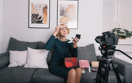 an elderly woman in the living room shoots a video for the network. Online training, video blog