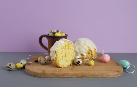 Traditional cake or sweet bread, quail eggs in a clay mug on a wooden cutting board.