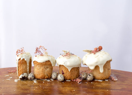 Festive cakes with white glaze quail eggs on the festive table. Preparations for Easter