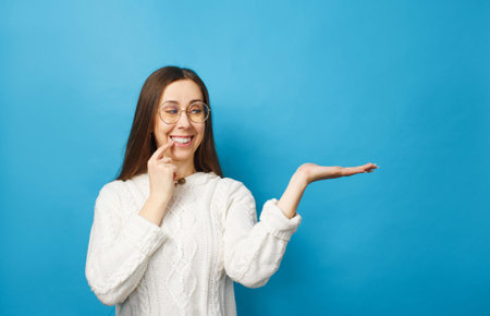 A young beautiful woman with glasses is holding something on an isolated background