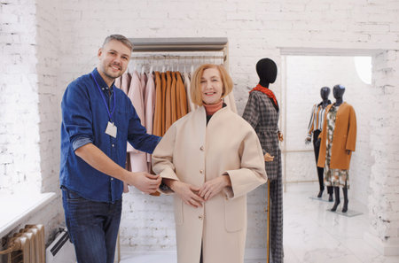 a male sales consultant serves an elderly woman in a clothing store. Policy customer service.