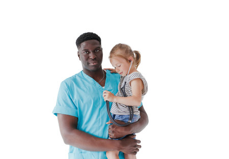 An African doctor holds a cute little girl in his arms who plays the role of a doctor, holding a stethoscope, pretending to be a nurse, fun children's healthcareの写真素材