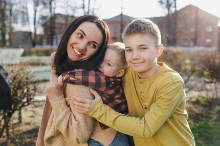 a happy mom plays with her two sons in a spring park.の写真素材