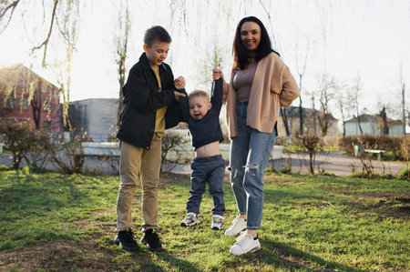 happy mom with two kids playing in the park