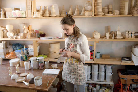 the artist in the workshop is engaged in the production of wooden toys. Eco-friendly wooden toys.の写真素材