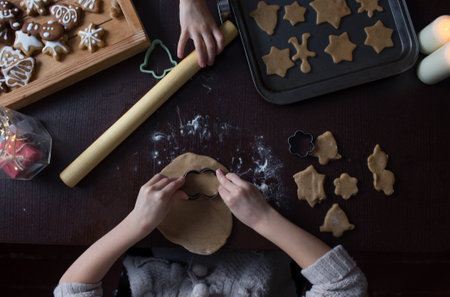 Child cuts cookies. Top view of kids hands with dough, rolling pin and dough.の写真素材
