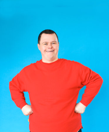 a man with down syndrome on an isolated blue backgroundの写真素材