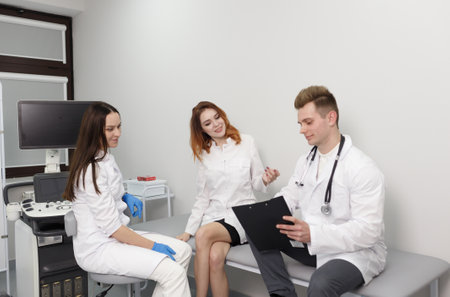 a group of young doctors communicate with each other sitting in the officeの写真素材